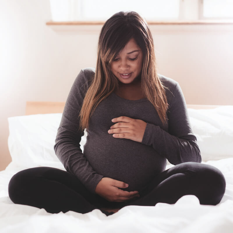 Photo of pregnant woman looking at her belly